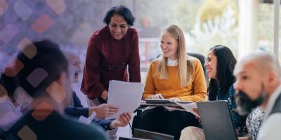 A group of smiling professionals looking at a bundle of papers