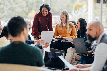 A group of people sitting in a circle having a meeting.