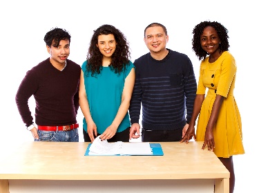 A group of four people looking at a document together at a table. 