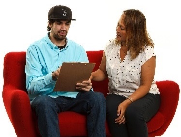 A woman helping a man read a document. 